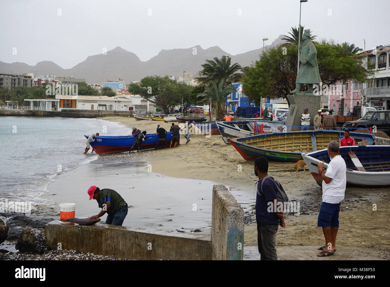 Staue of  Dogo Afonso, Mindelo, Fisher gutting a fish, fishermen pulling a boat  onshore, Sao Vicente Island, Cape Verde, Africa Stock Photo