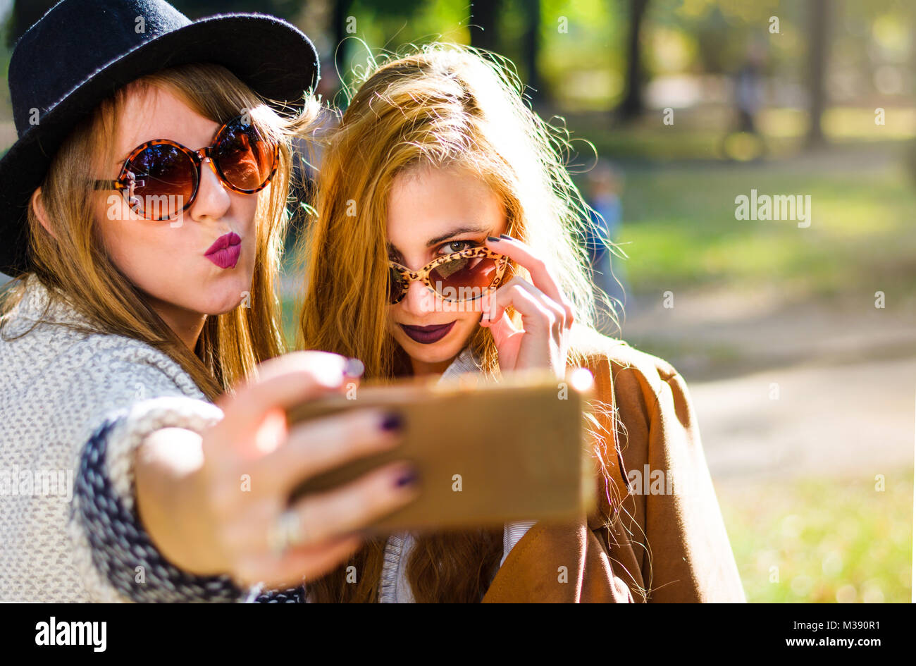 Urban girlfriends taking a selfie in the park Stock Photo