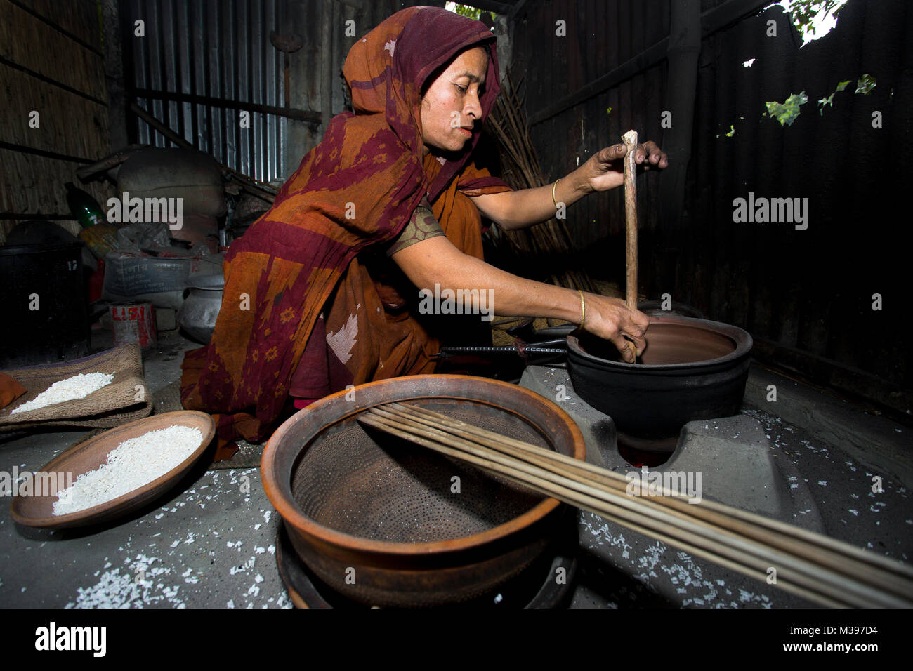 Moriom Bibi making Khoi (popped rice), people called ‘Bini Dhan er khoi ...