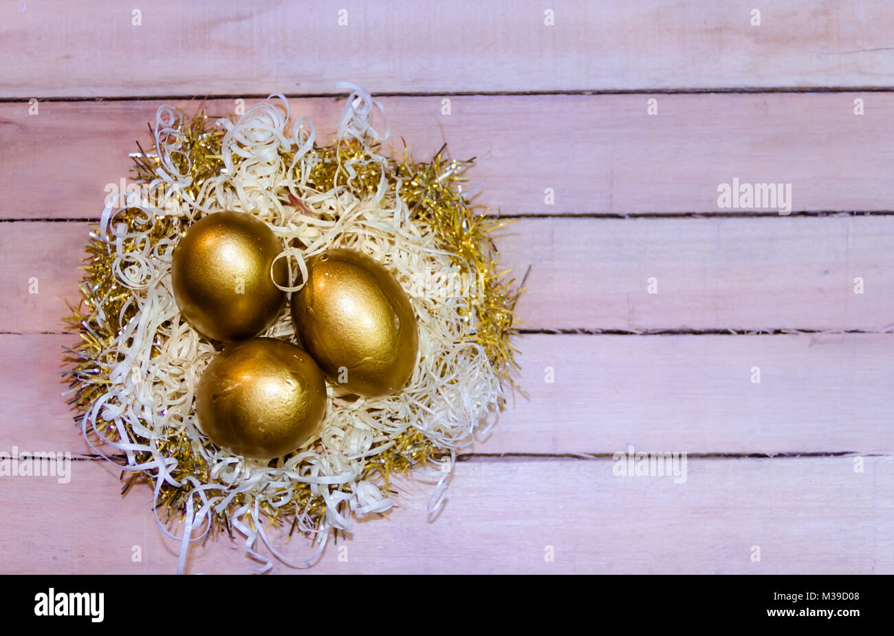 golden easter eggs in straw nest with rustic wooden background Stock ...