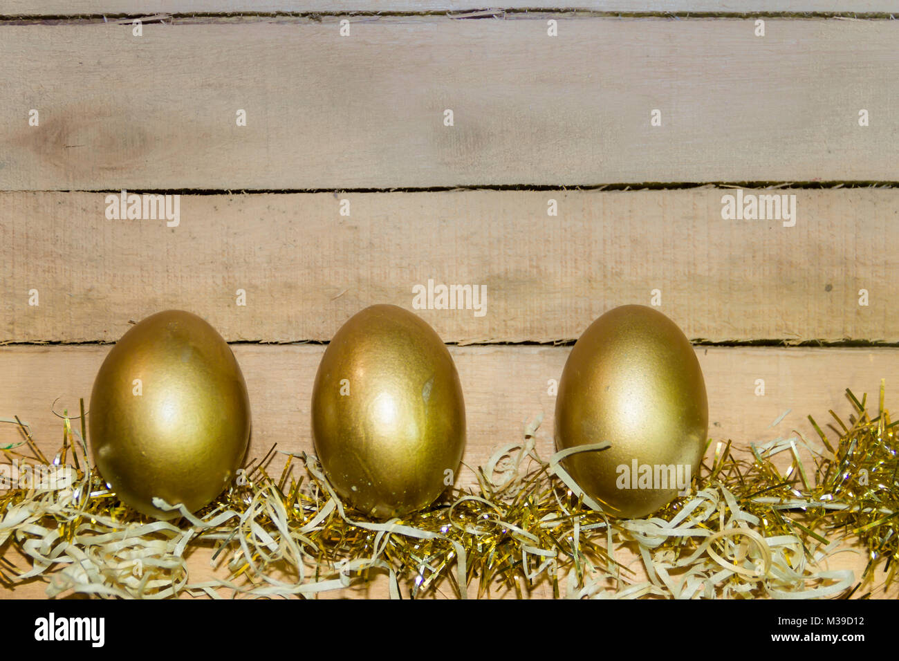 golden easter eggs in straw nest with rustic wooden background Stock ...