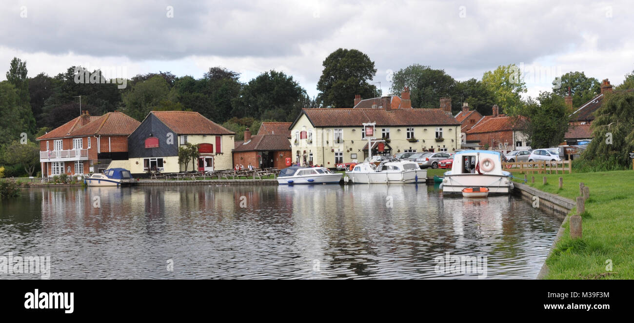 The Riverside in the village of Coltishall, Norfolk Broads, UK with boats and local pub Stock Photo