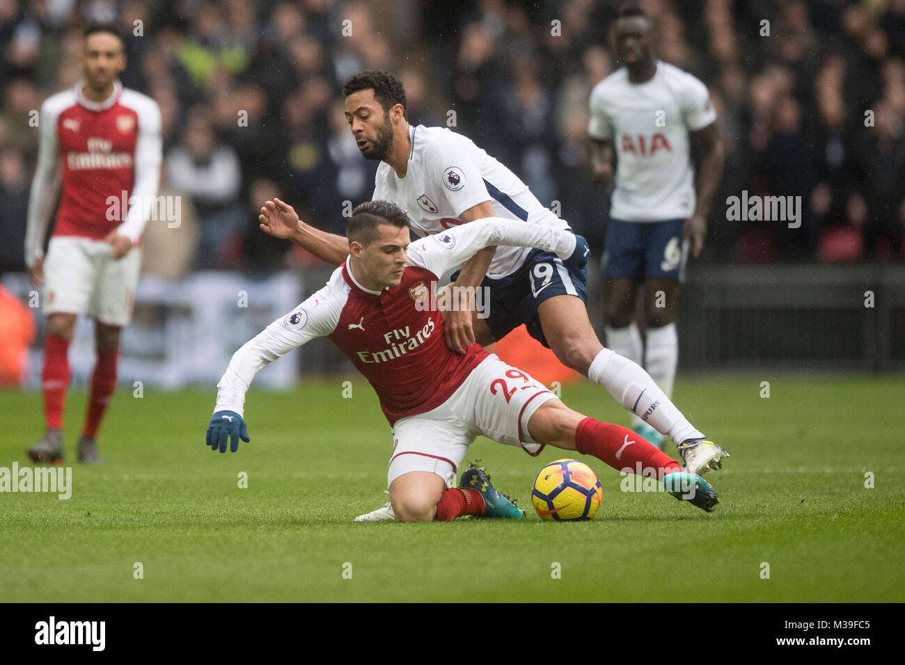 Arsenal's Granit Xhaka (left) and Tottenham Hotspur's Mousa Dembele during the Premier League match at Wembley Stadium, London. Stock Photo