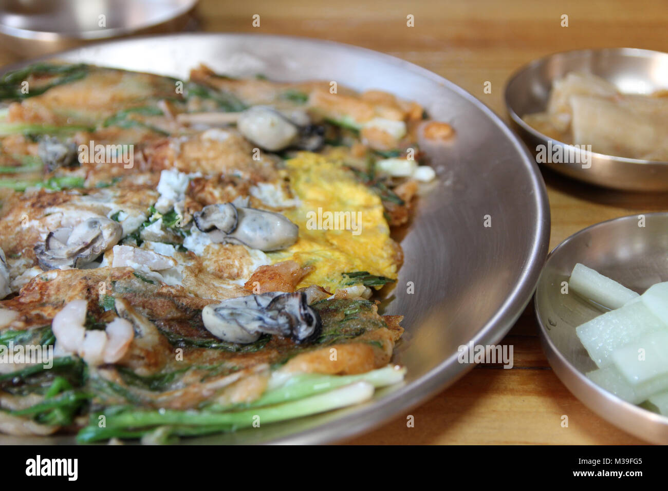 Focus on oyster on the Korean pancake with the leek and egg at Korean
