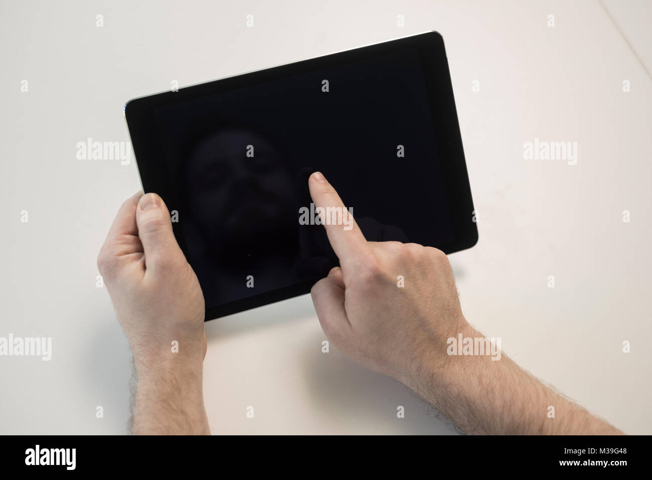 male and female mens and womens hands using an ipad computer tablet for ...