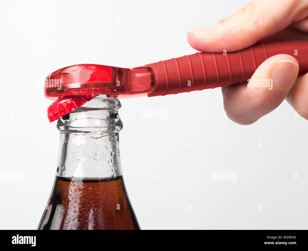 A hand using bottle opener to open the soda Stock Photo Alamy