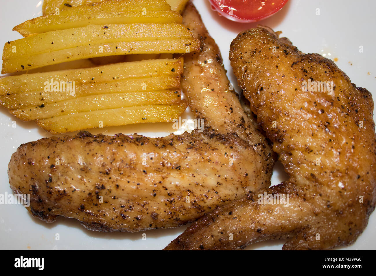 Chicken wings with potatoes laid out on a plate Stock Photo
