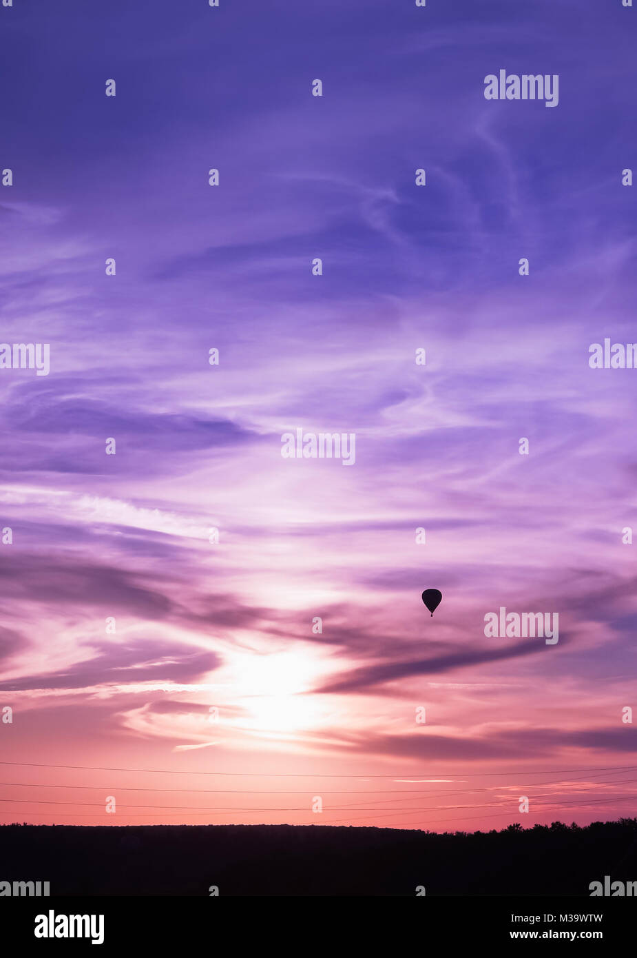 Hot air balloon flies in colorful evening sky, vertical background photo Stock Photo