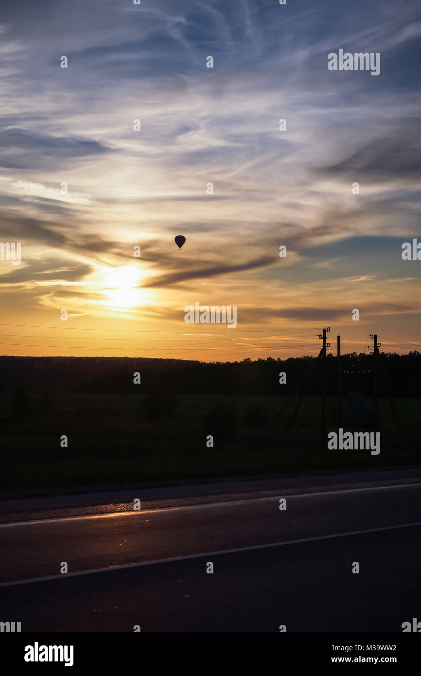 Hot air balloon flies in the evening sky, vertical photo Stock Photo