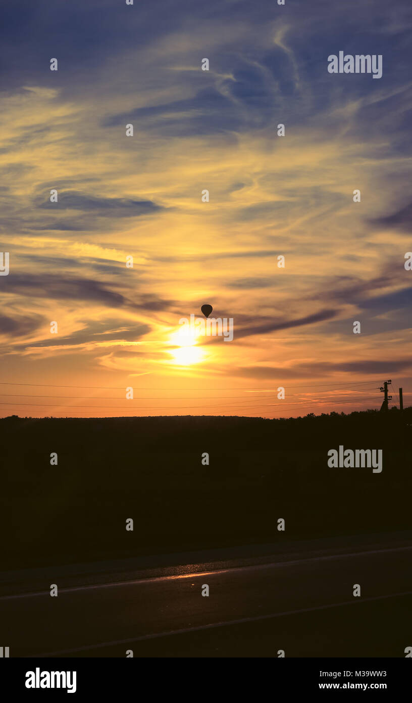 Hot air balloon flies in the evening sky, vertical background photo Stock Photo