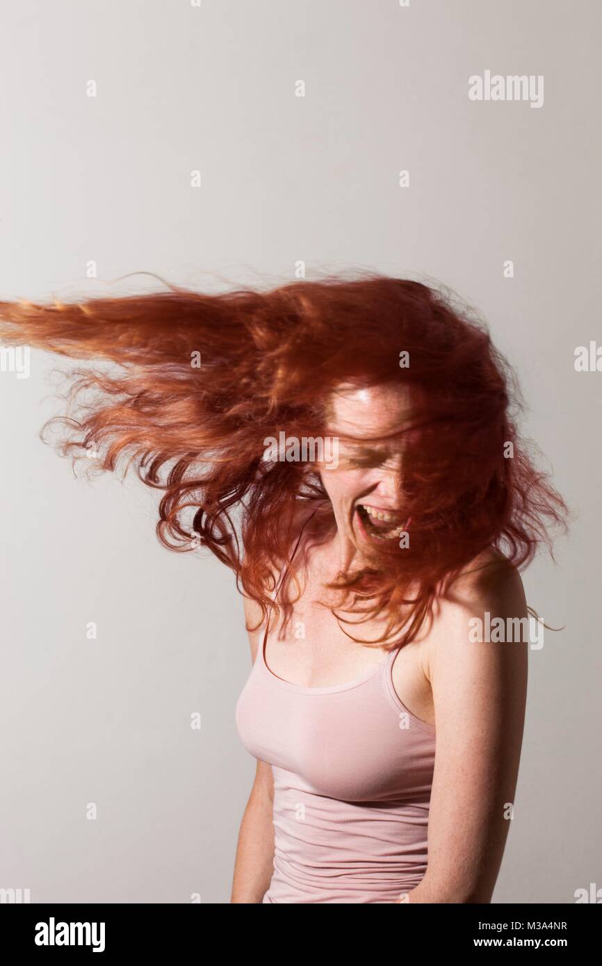 MODEL RELEASED. Angry woman with red hair screaming with rage. Stock Photo