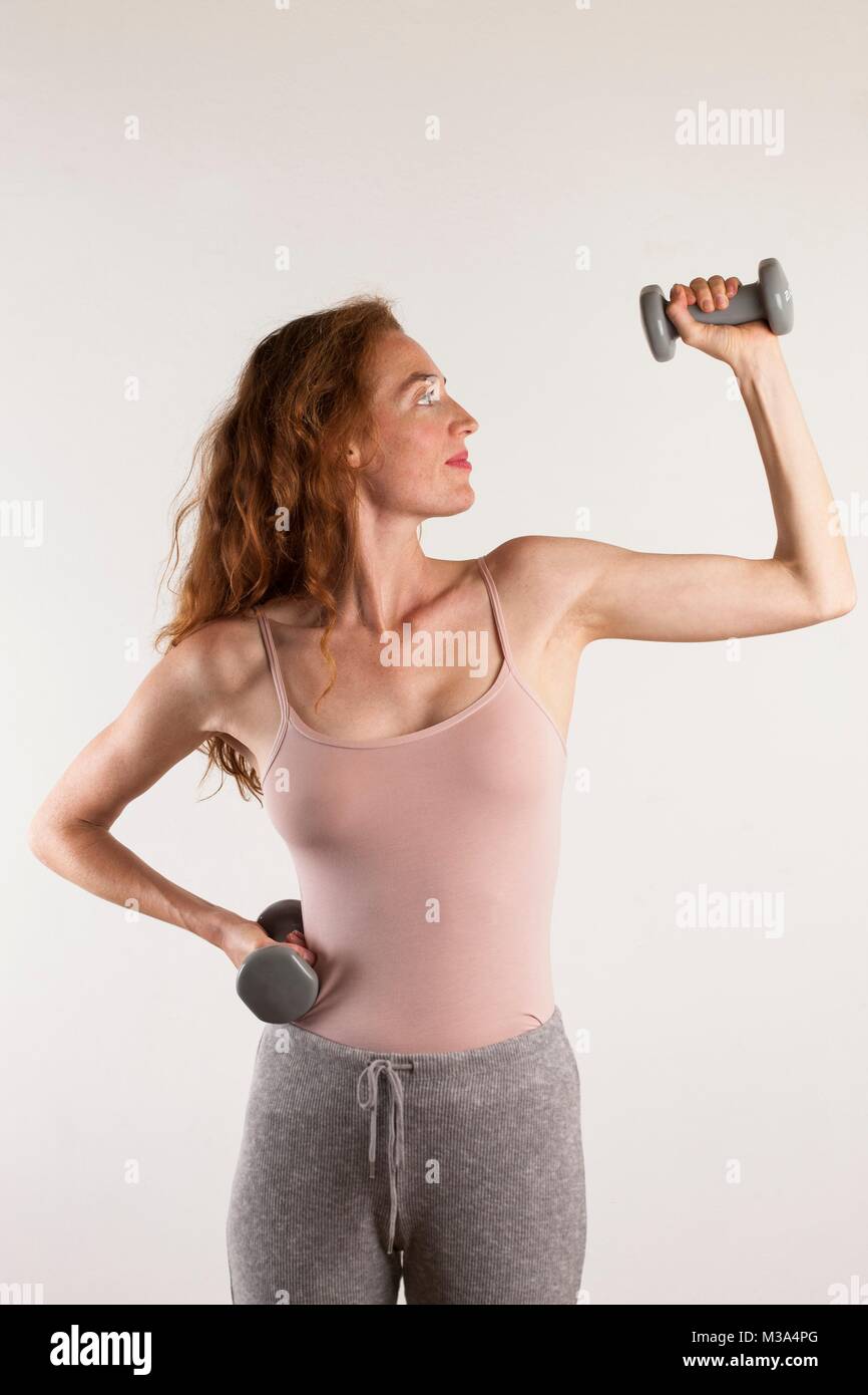 MODEL RELEASED. Woman exercising with dumb bells. Stock Photo