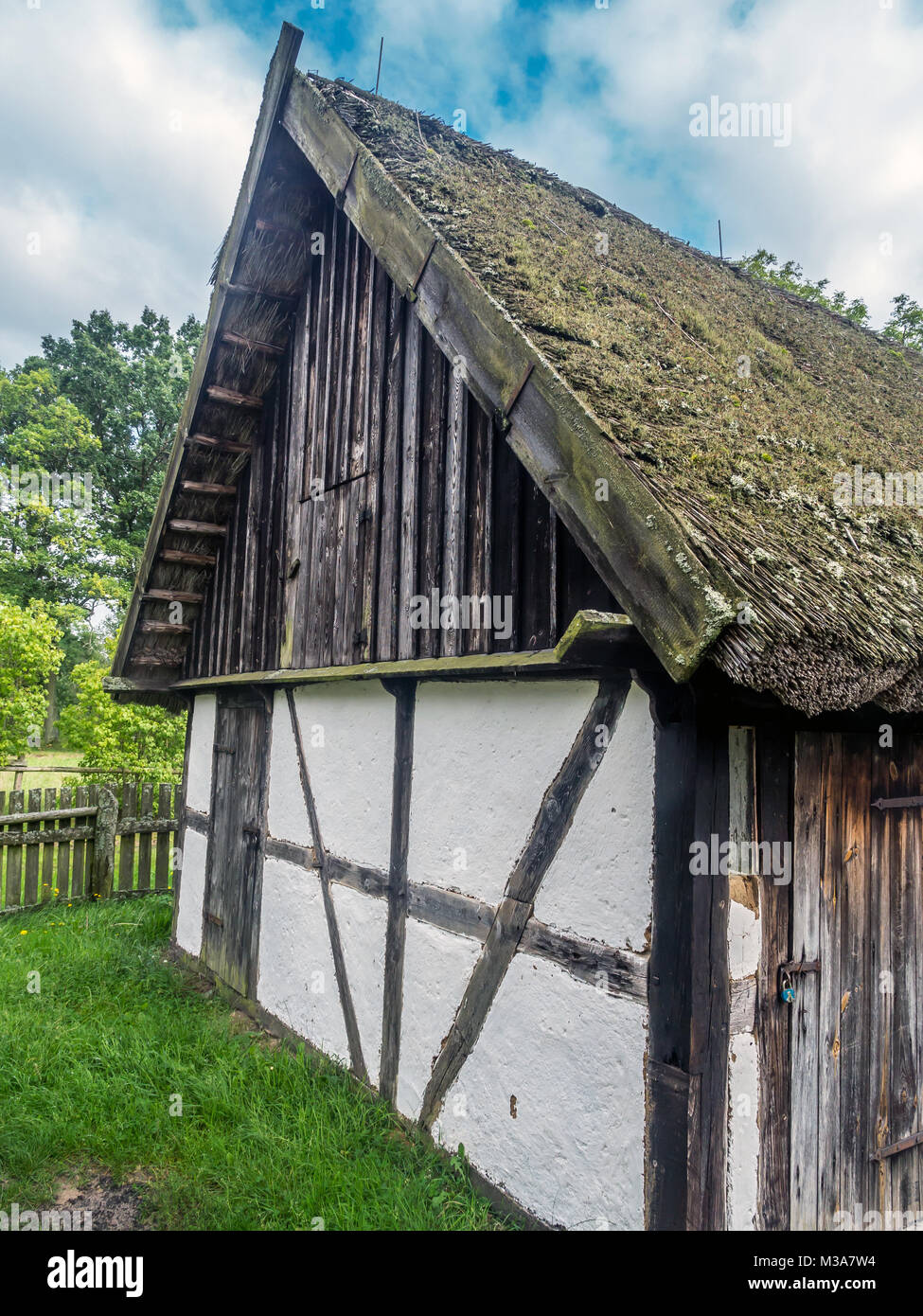 Old wooden farmstead with typical timber framing, part of heritage park in Kluki, Poland Stock Photo