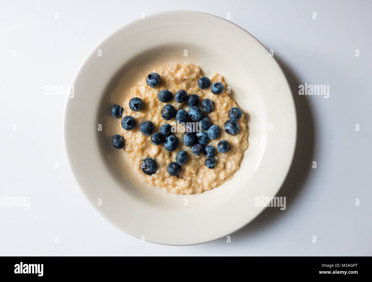 A bowl of porridge and blueberries Stock Photo