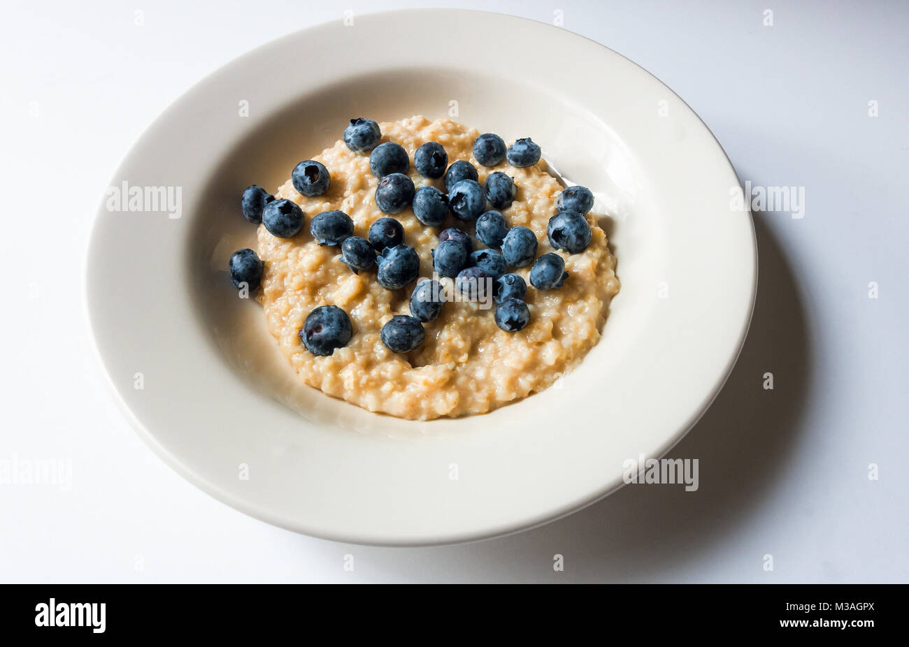 A bowl of porridge and blueberries Stock Photo