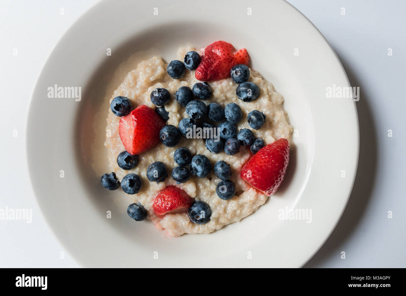 A bowl of porridge with blueberries and strawberries Stock Photo