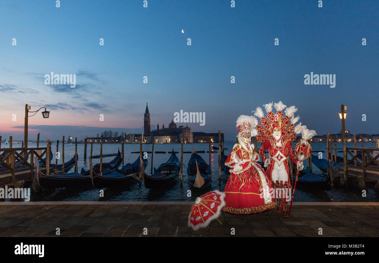 Venice, Italy 10th February, 2018. People in costumes and masks pose at dawn during a beautiful sunrise near St Mark's Squarei during Venice Carnival. Venice weather. Credit: Carol Moir / Alamy Live News. Stock Photo