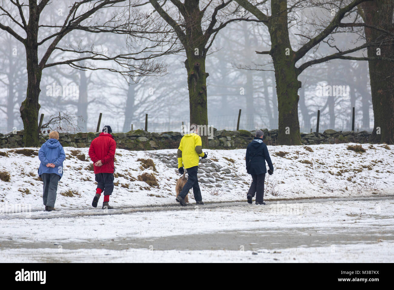 A group of walkers in multicoloured winter clothing walking along the