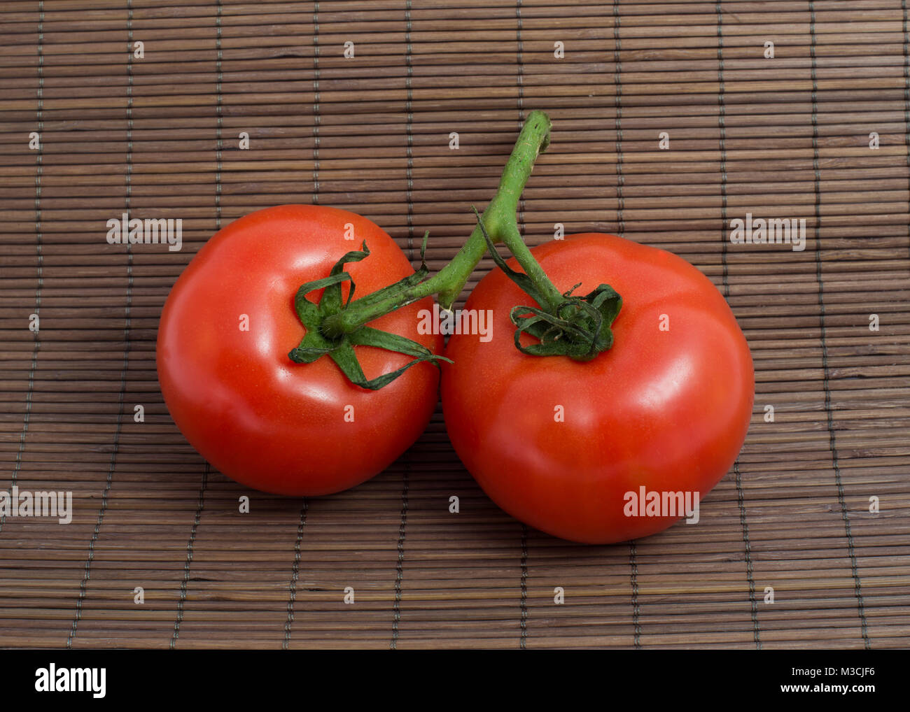 Isolated image of ripe tomatoes on a brown background Stock Photo - Alamy