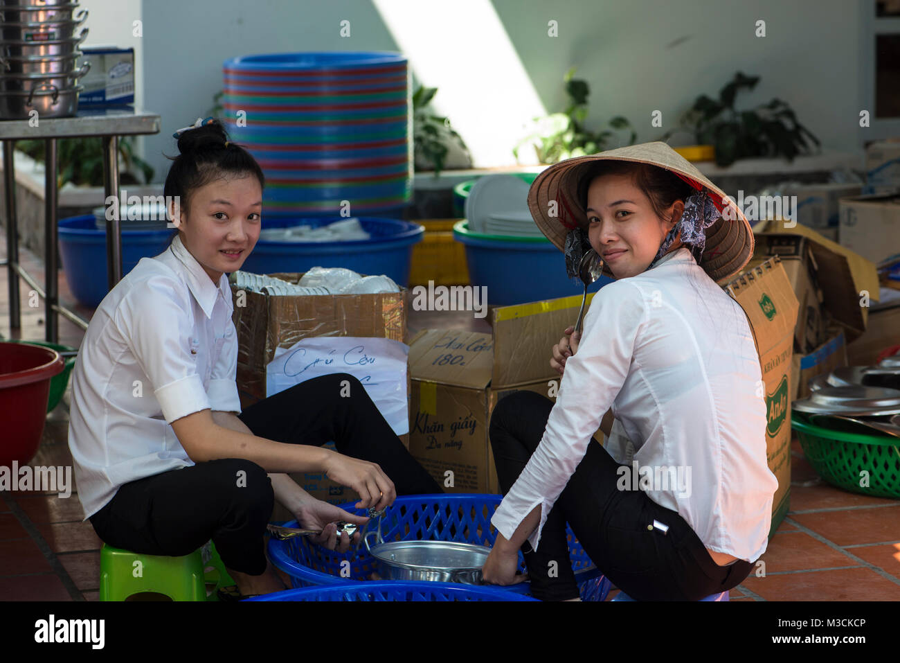 Two young Vietnamese women washing dishes Stock Photo