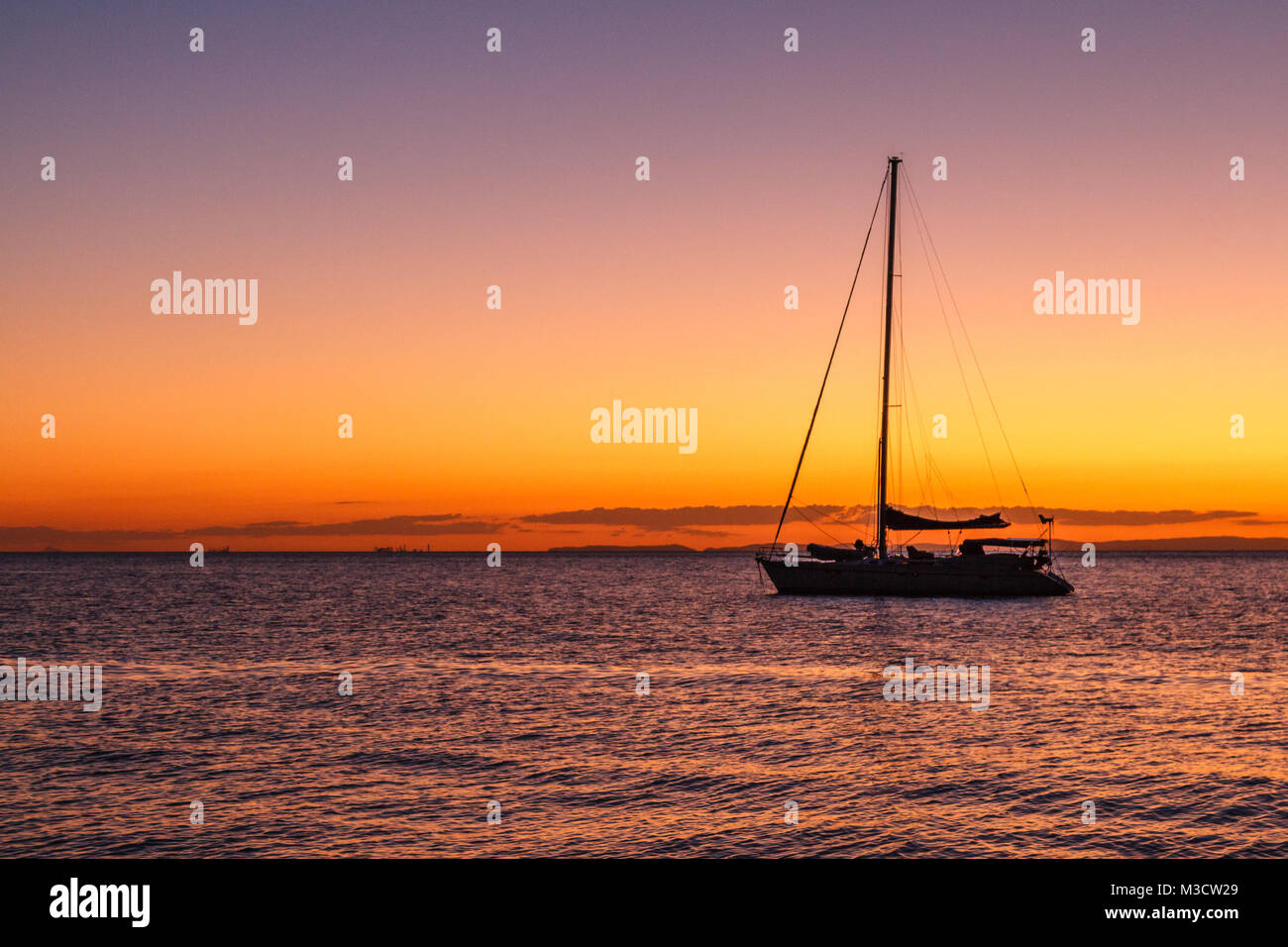 Silhouette of yacht at sunset at Moreton Bay, Queensland, Australia Stock Photo