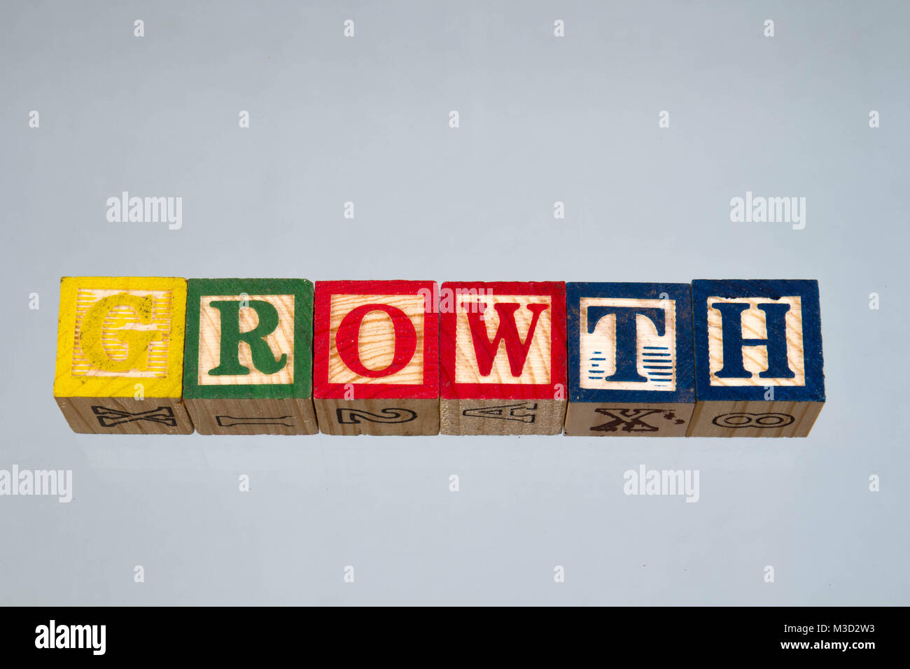 The phrase growth displayed visually on a light background using colorful wooden toy blocks, image in landscape format with copy space Stock Photo