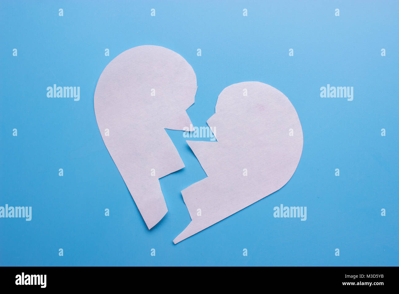 Broken heart on blue background. breakup concept Stock Photo - Alamy