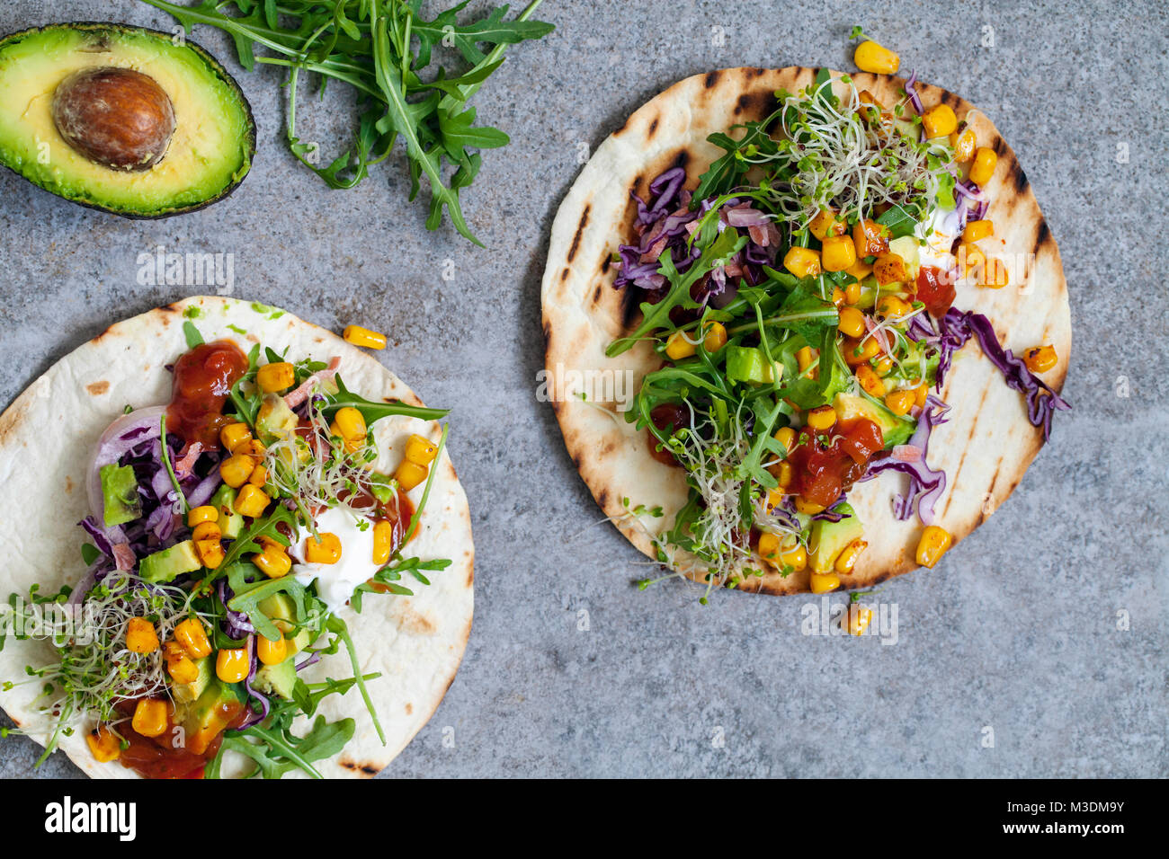 Vegan tortillas with sweetcorn, avocado, red cabbage and broccoli sprouts Stock Photo