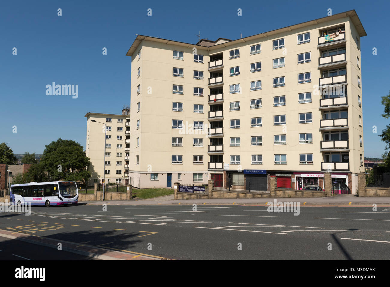 White-painted Newcastle House flats stand out against blue sky (city centre tower block of social housing) - Bradford, West Yorkshire, England, UK. Stock Photo