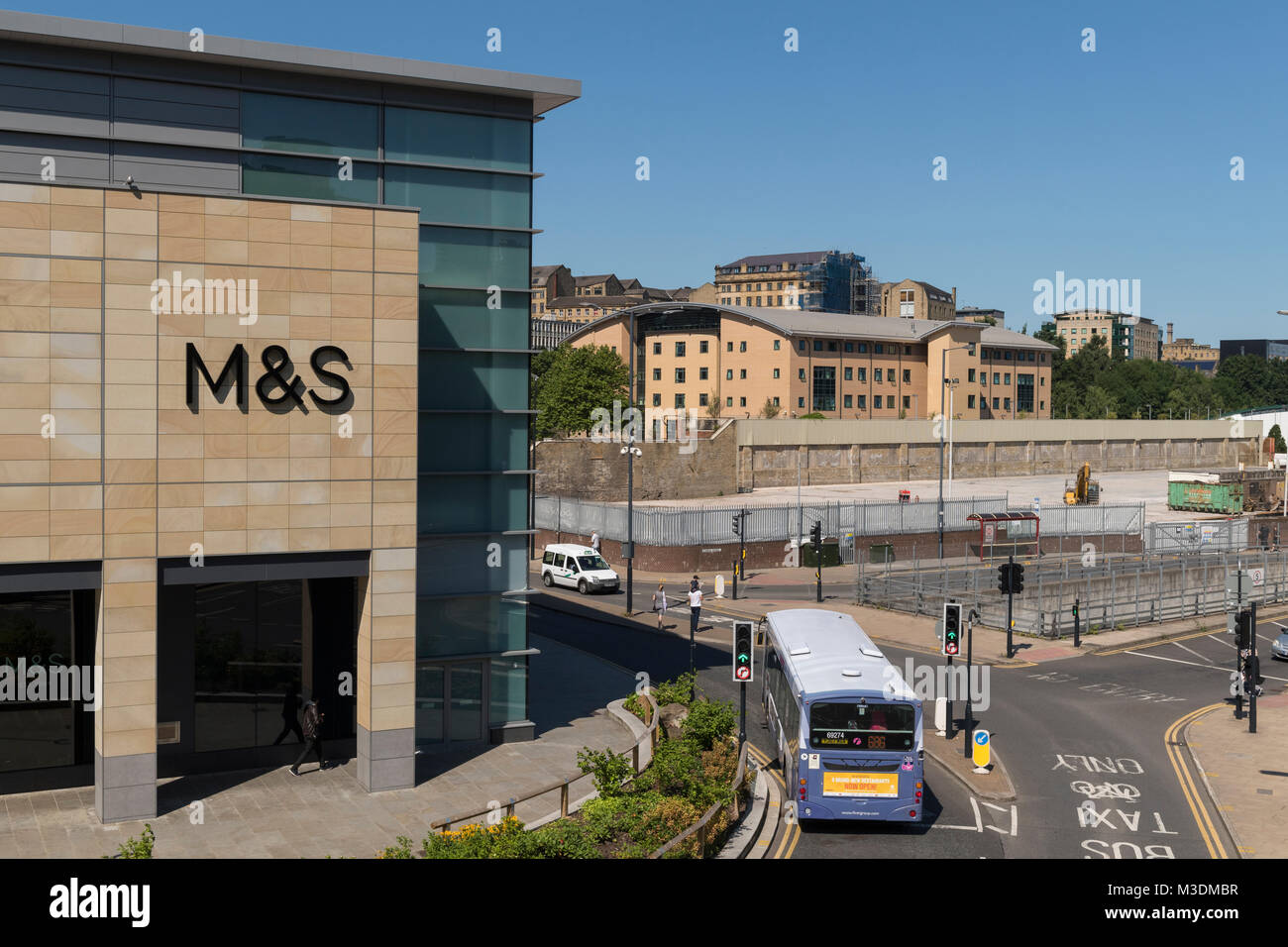 Corner of Marks & Spencer store in The Broadway shopping centre with traffic at road junction in city centre - Bradford, West Yorkshire, England, UK. Stock Photo