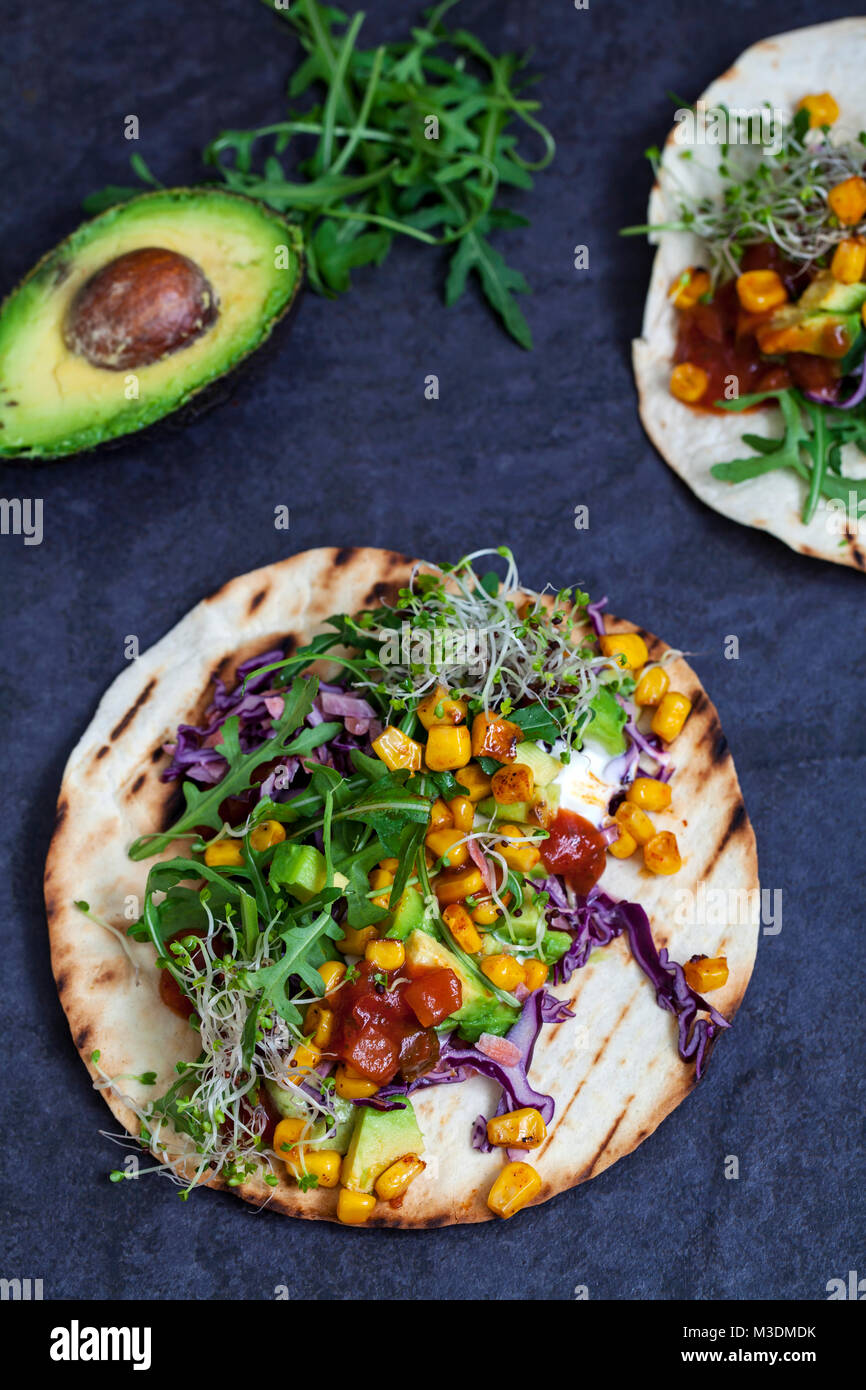 Vegan tortillas with sweetcorn, avocado, red cabbage and broccoli sprouts Stock Photo