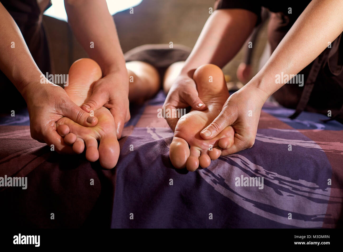 Massage in four hands on feet in the spa salon.  Stock Photo