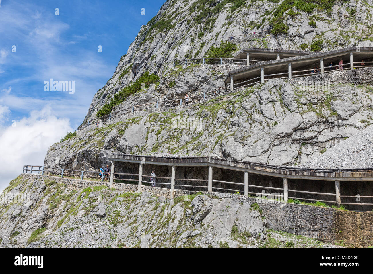 People at hiking trail through Austrian mountains to ice cave Stock Photo