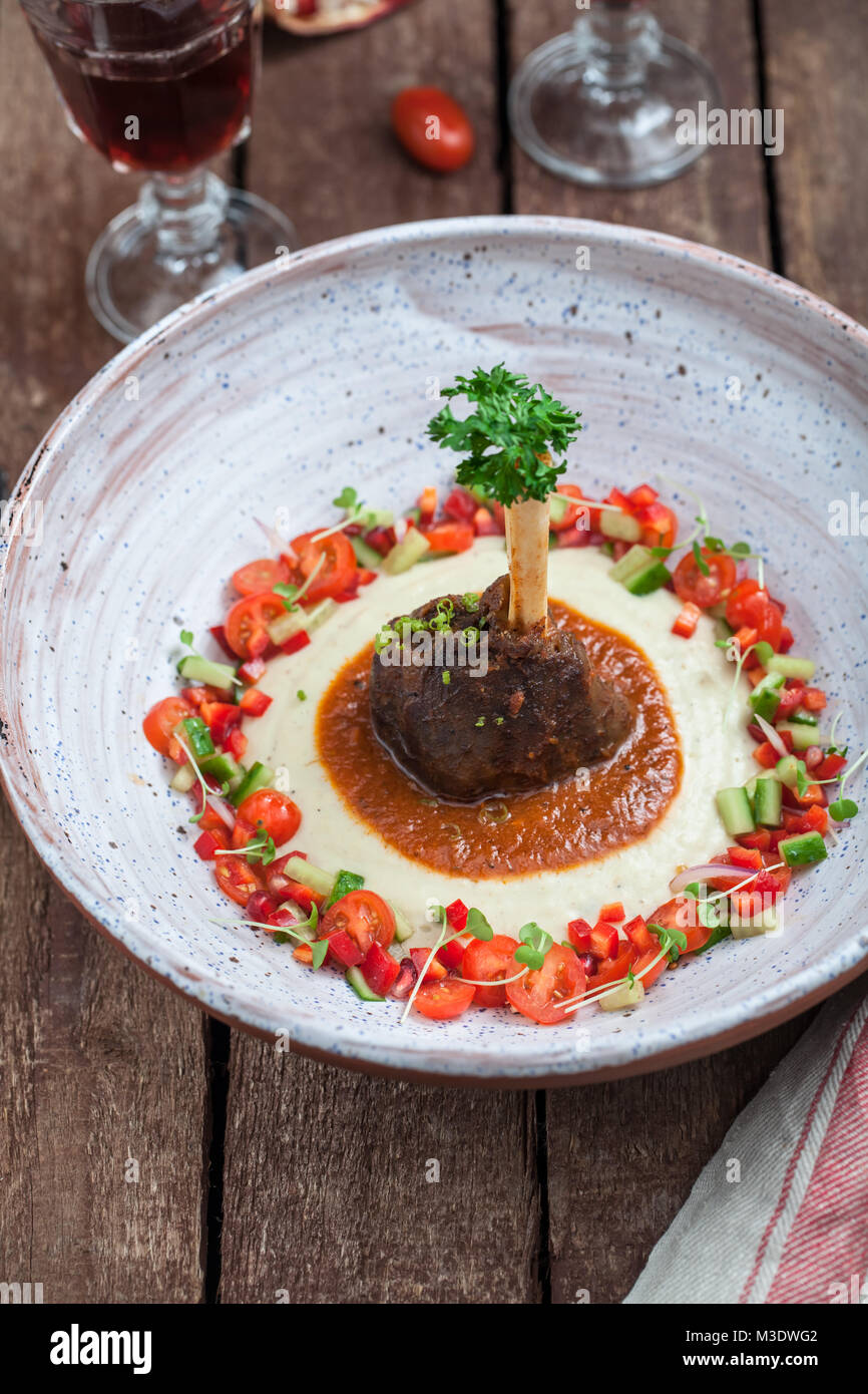 Lamb shank with eggplant puree and fresh vegs, traditional turkish dish Stock Photo