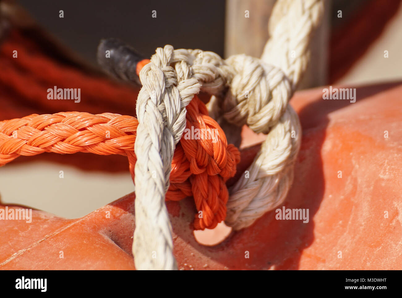 Rope for mooring a vessel is adhered to a pier Stock Photo