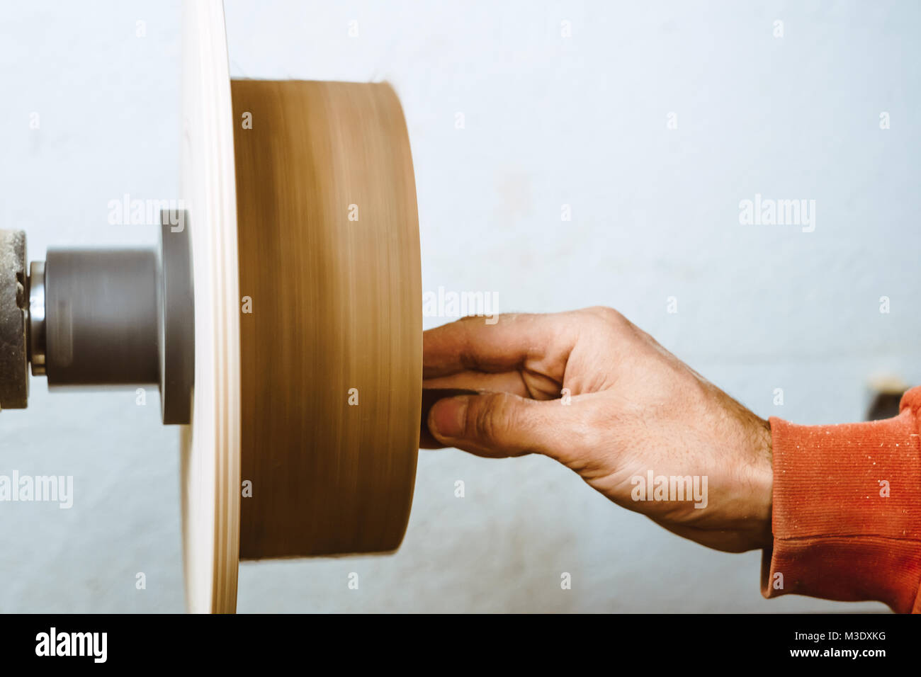 Wood turners using sandpaper polished wood on a lathe Stock Photo Alamy