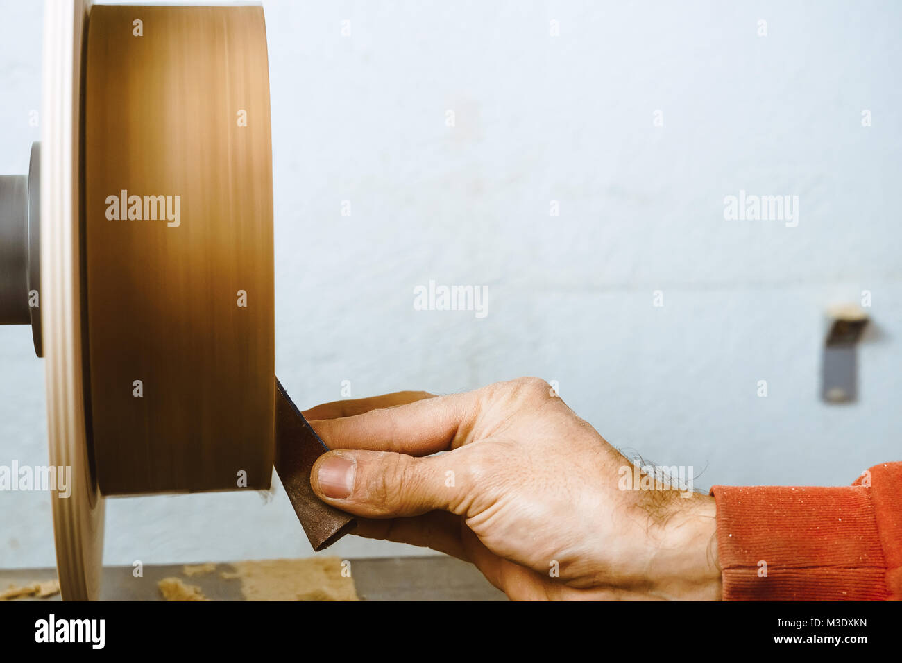 Wood turners using sandpaper polished wood on a lathe Stock Photo Alamy