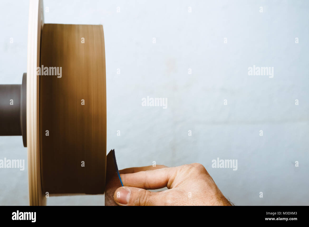 Wood turners using sandpaper polished wood on a lathe Stock Photo Alamy