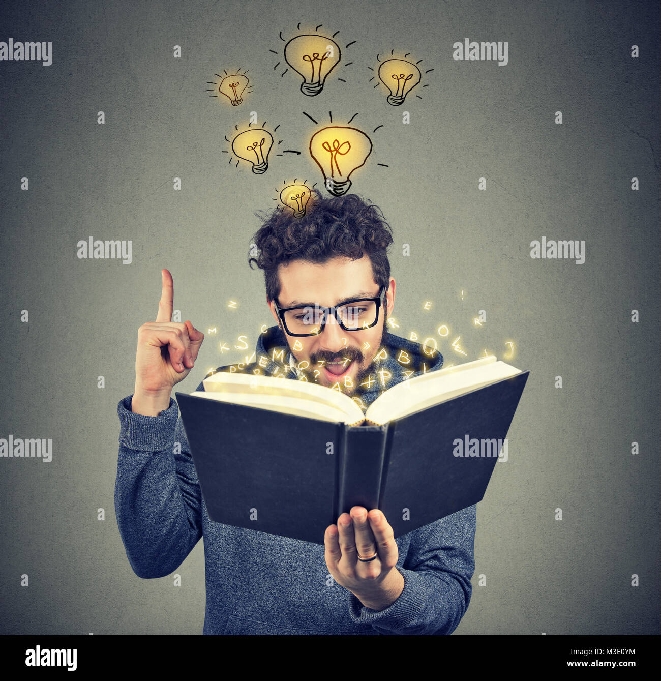 Young man having brilliant idea to come up in mind while reading smart book. Stock Photo
