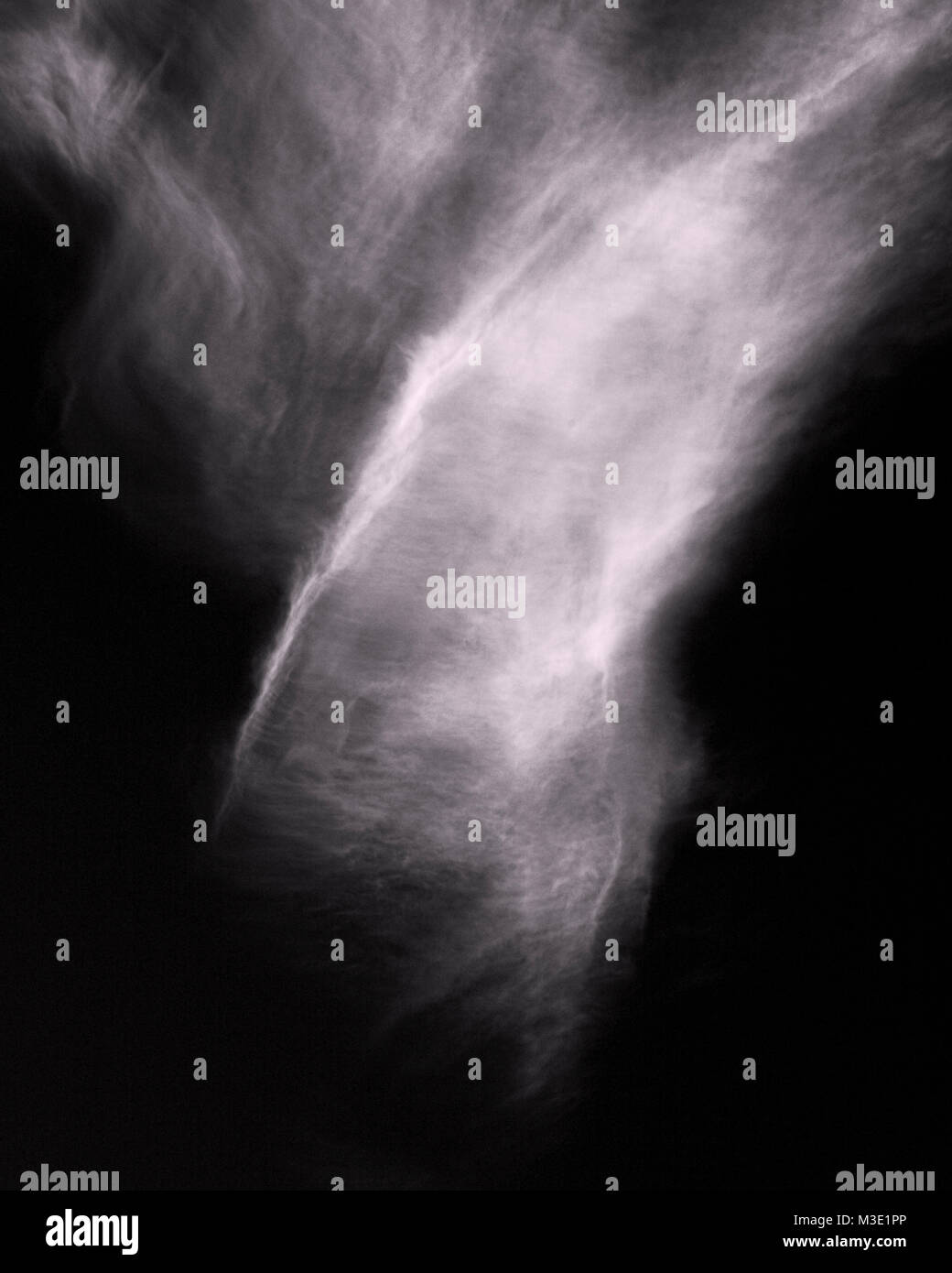 Monochrome image of a fan of white cirrus cloud in a black sky Stock Photo