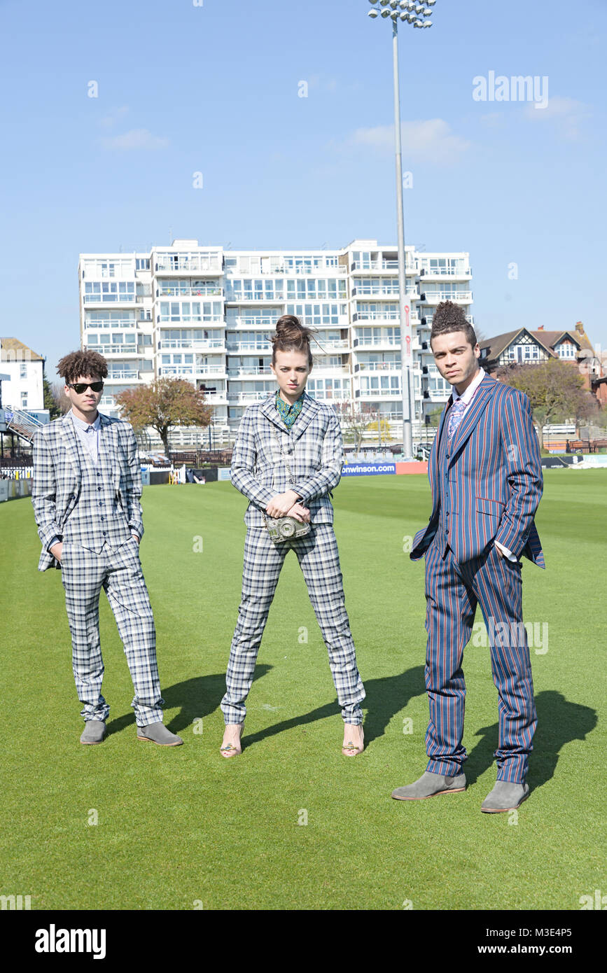 Two well dressed handsome dark skinned guys are at a Cricket Ground