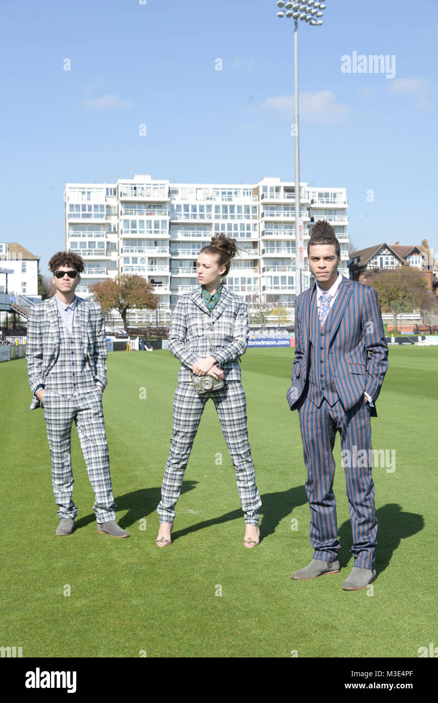 Two well dressed handsome dark skinned guys are at a Cricket Ground