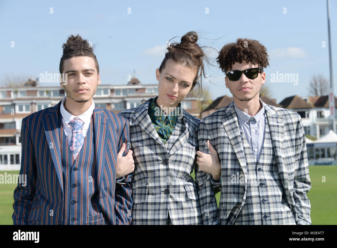 Two well dressed handsome dark skinned guys are at a Cricket Ground