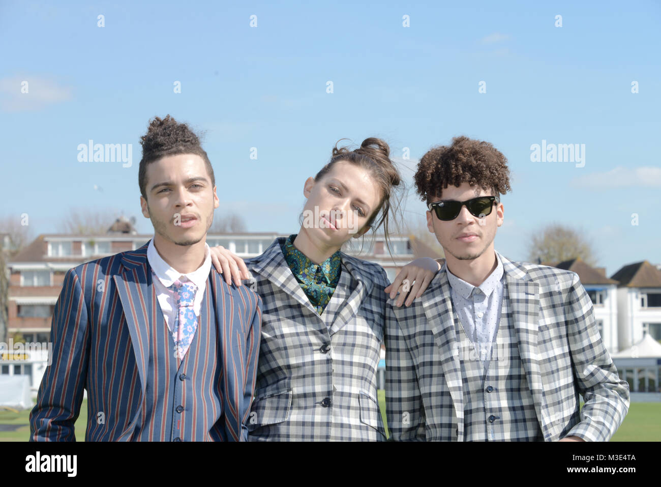 Two well dressed handsome dark skinned guys are at a Cricket Ground