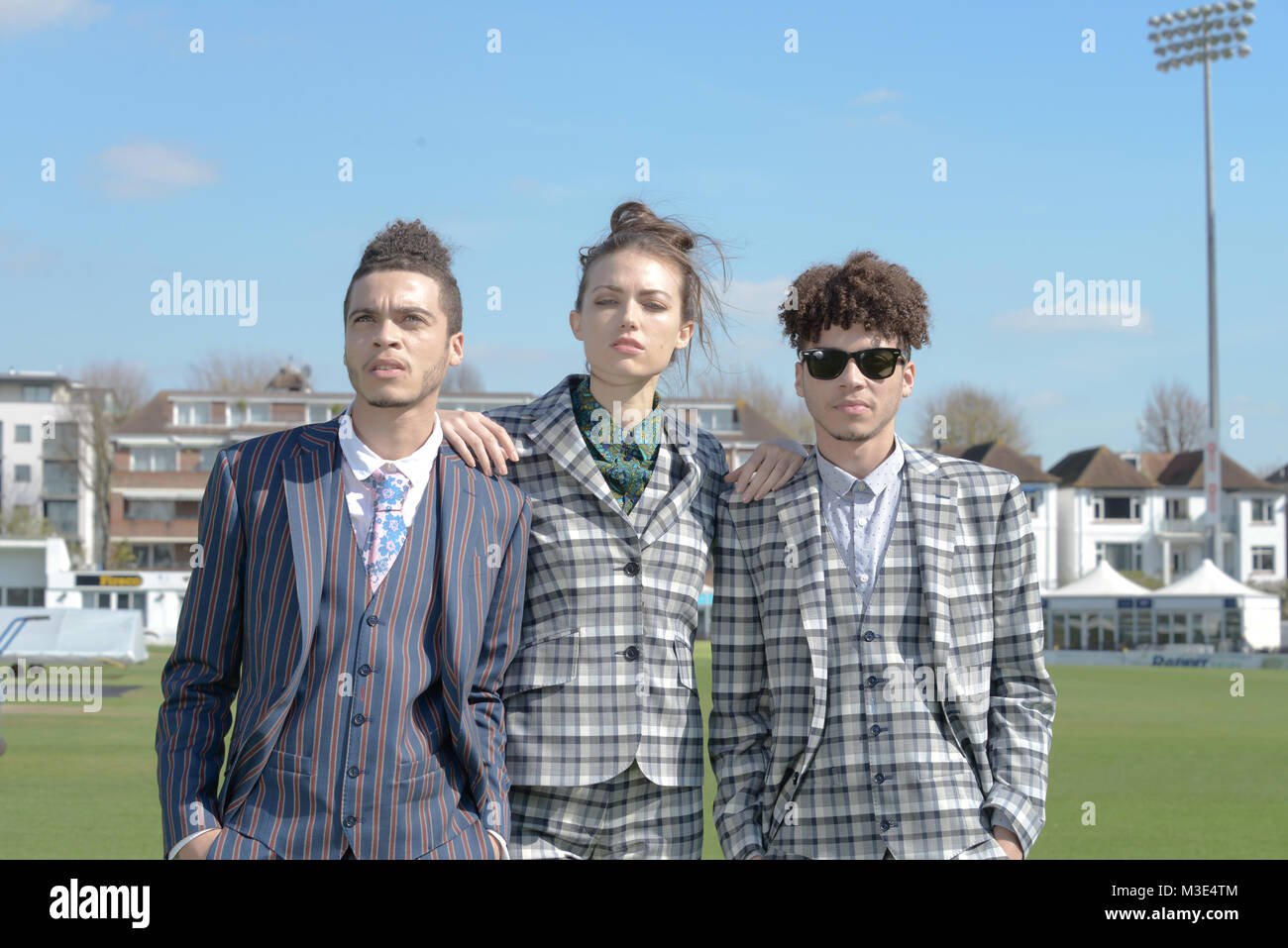 Two well dressed handsome dark skinned guys are at a Cricket Ground