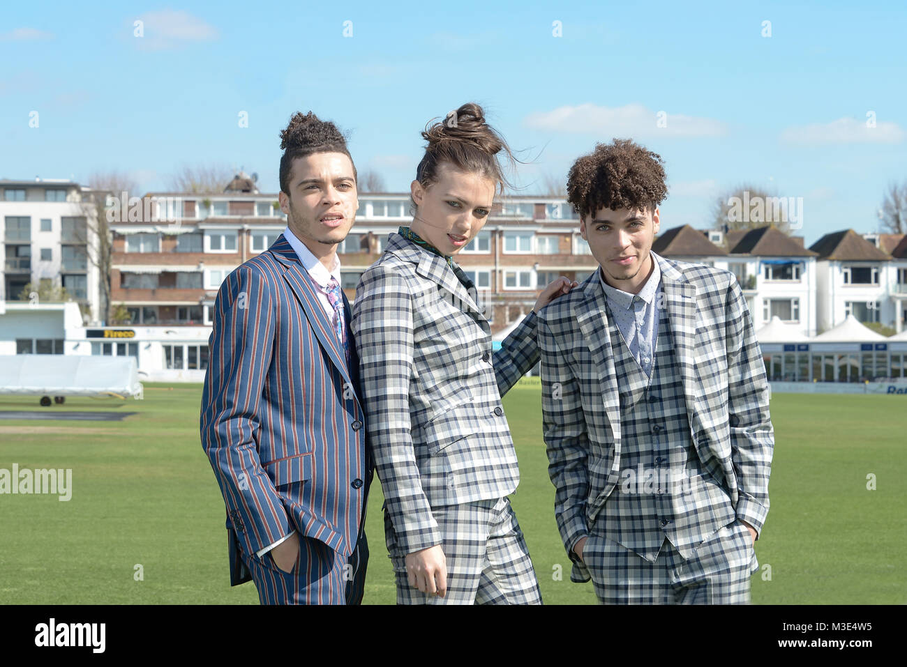 Two well dressed handsome dark skinned guys are at a Cricket Ground