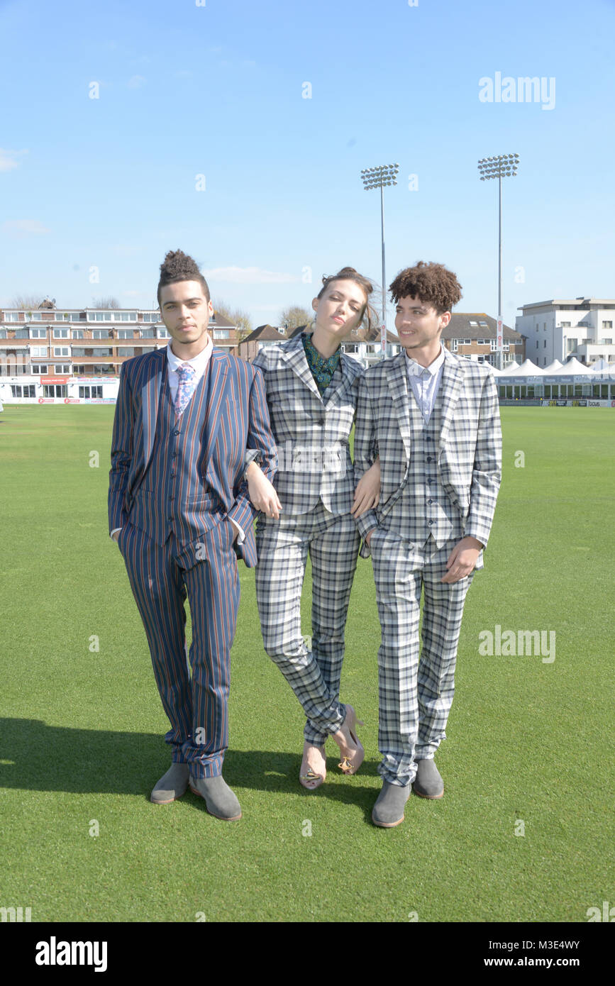 Two well dressed handsome dark skinned guys are at a Cricket Ground