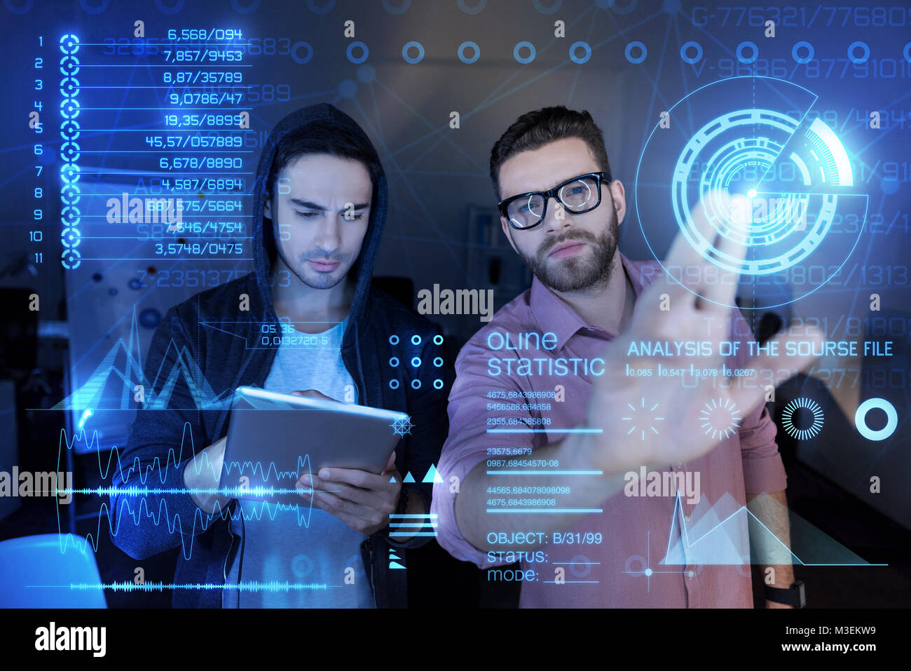 Smart programmers looking serious while working together Stock Photo