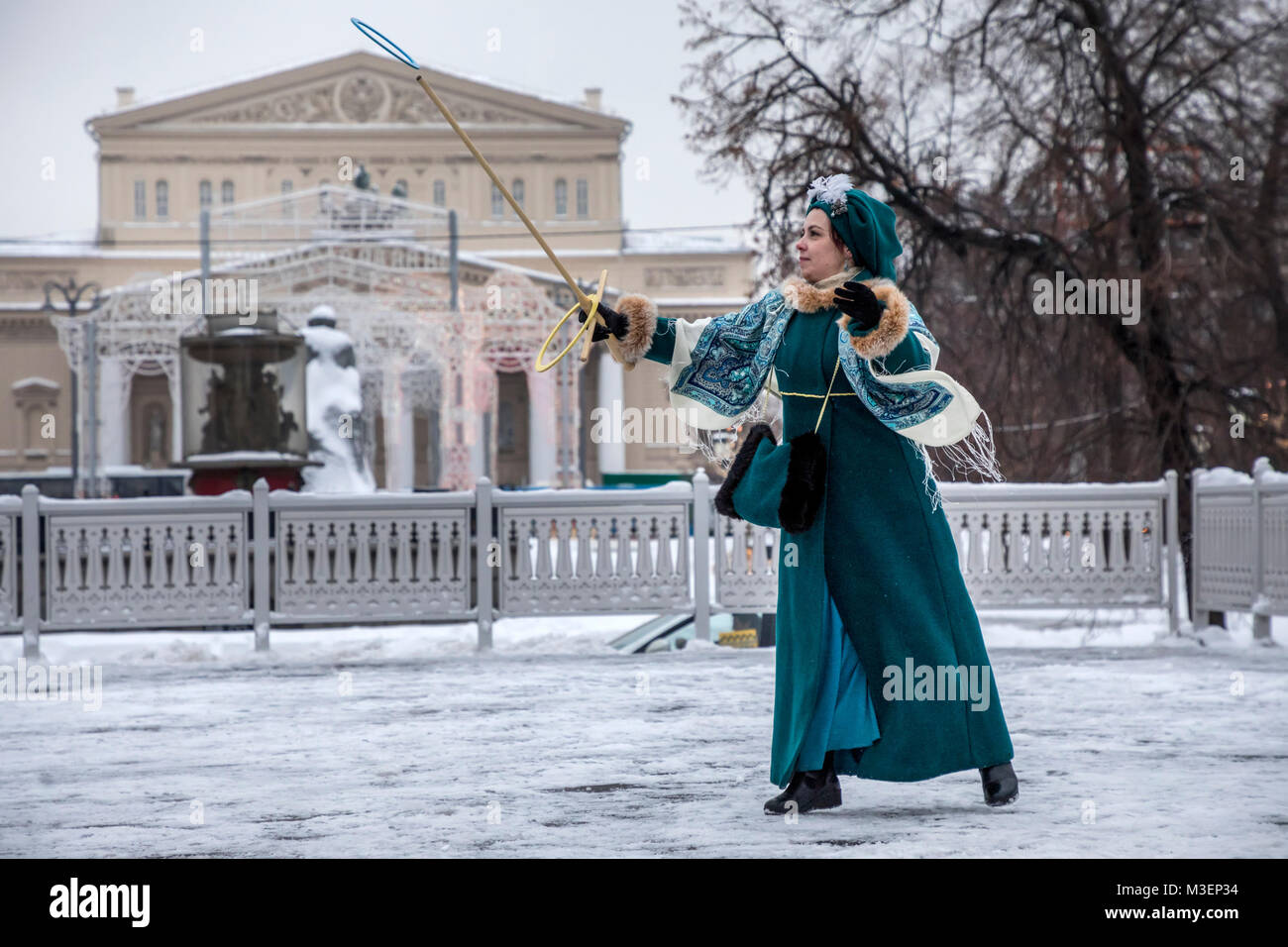 A lady in historical dress plays the game Serso on the Revolution Square on the background of the Bolshoi Theater in  center of Moscow, Russia Stock Photo