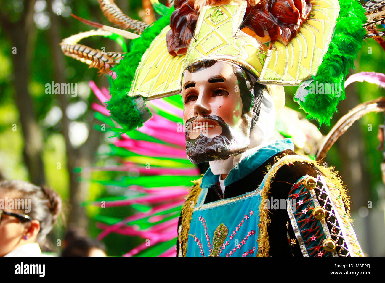 Carnival scene, a mexican Huehue dancer wearing a traditional mexican folk costume made of satin, plume and wooden mask rich in color Stock Photo